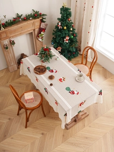 Detailed top view of a festive Christmas tablecloth with Santa Claus print and lace edges