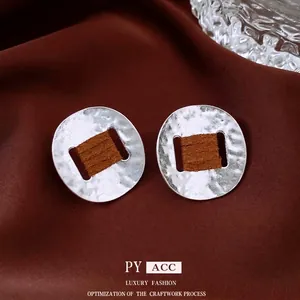 Silver oval earrings with hammered metal texture and brown leather inlay for women