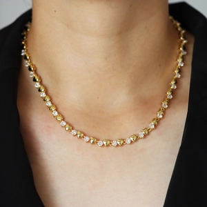 Detail of gold heart necklace with sparkling clear cubic zirconia on a female model
