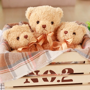 Three small light brown plush teddy bears with champagne silk bows in a rustic wooden crate
