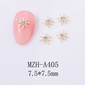 Macro detail of 7.5x7.5mm gold starburst alloy nail charms with crystal rhinestones