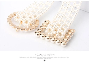 Close-up of elegant pearl waist chains with gold round and square metal buckles