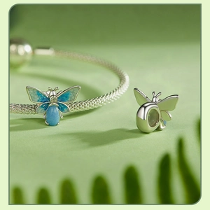 Macro detail of S925 sterling silver bee charm with blue enamel on snake chain