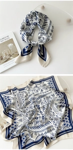 Close-up of silk square scarf featuring blue floral print on white background