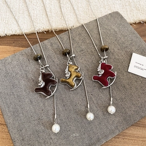 Détails de trois pendentifs cheval à bascule floqués avec perles et chaînes serpentines