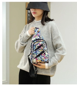 Detail of colorful abstract patterned nylon crossbody bag with adjustable strap and zippers