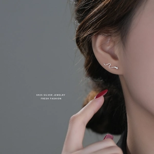 Minimalist S925 sterling silver snake stud earrings worn by a model in a profile view