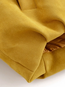 Macro shot of ginger yellow suede jacket fabric texture and fine stitching detail
