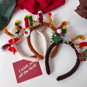 Detailed close-up of plush Christmas headbands with reindeer antlers and festive trees