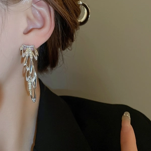 Elegant silver tassel earrings with zircon-set layered metal rings on model
