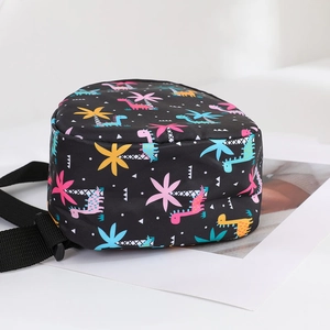 Close-up of black nylon kids bag featuring colorful cartoon dinosaur and palm tree patterns