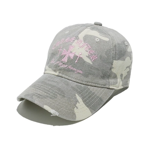 Detail of pink embroidery and distressed brim on camouflage vintage baseball cap