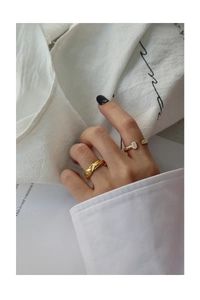 Detail of S925 silver gold rings with lava texture and opal stone on model hand