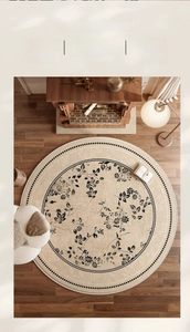 Detail of round French vintage rug with black floral patterns on a beige background