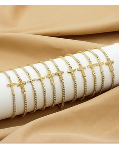 Detailed close-up of golden tennis bracelets with zircon-studded cross pendants