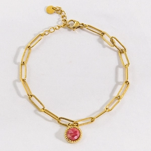 Gold chain bracelet with textured paperclip links and a faceted round pink gemstone pendant