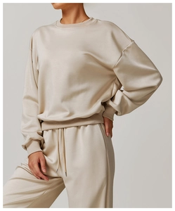 Détail d'un sweat à col rond beige et d'un pantalon de jogging en maille de qualité