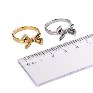 Classic bow-shaped rings in gold and silver finish shown with a metric size ruler