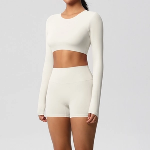 Detail of ivory yoga set featuring high-waisted shorts and long sleeve crop top fitness wear