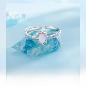 Macro detail of S925 sterling silver ring with water-drop pink opal on blue crystal
