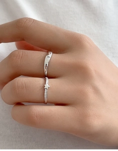 Close-up of S925 sterling silver couple rings with star engravings and diamond accents