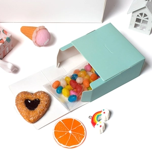 Mint green sliding paper gift box for candy and jewelry on a decorative white desk