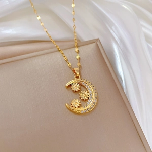 Detailed close-up of golden crescent moon pendant with micro-pave crystals and floral accents