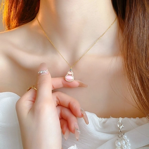 Close-up of pink opal gourd pendant necklace with sparkling zircon pavé in gold finish