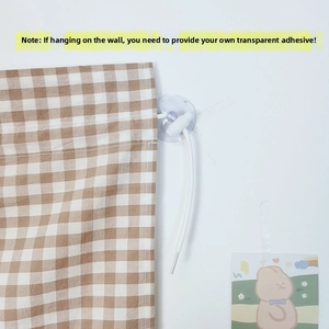 Detail showing the brown checkered fabric curtain with a white drawstring and suction cup