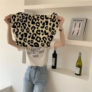 Detail of a chic leopard print canvas tote bag styled in a minimalist interior setting