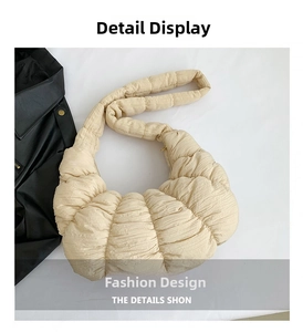 Close-up of the pleated texture and soft stitching on this beige dumpling crescent bag