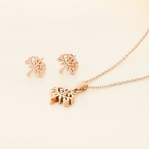 Detailed view of rose gold Tree of Life necklace and matching stud earrings set