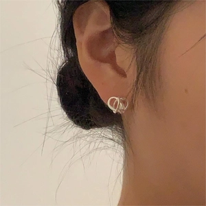 Minimalist 925 sterling silver knotted hoop earrings worn by a model in a close-up view