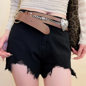 Detail of vintage heart-shaped carved buckle and silver metal chain on brown leather belt