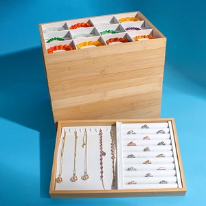 Bamboo jewelry tray set with white interior for rings and necklaces on blue background