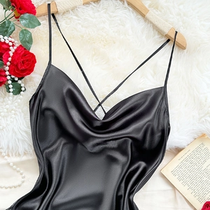 Elegant black satin slip nightdress with cowl neck and cross straps on white faux fur background