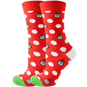 Gros plan de chaussettes festives rouges à pois blancs avec un motif de chiot de Noël
