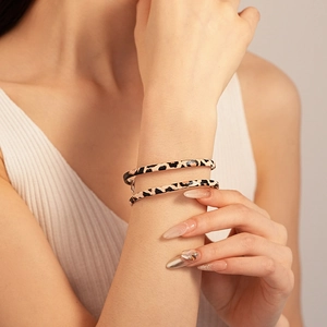 Detail of leopard print double-wrap leather bracelet on wrist with refined texture