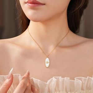 Detailed close-up of a vintage oval gold pendant necklace featuring a white mother of pearl star