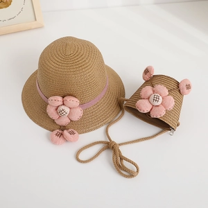 Detailed view of straw hat and matching bag with decorative pink fabric flowers