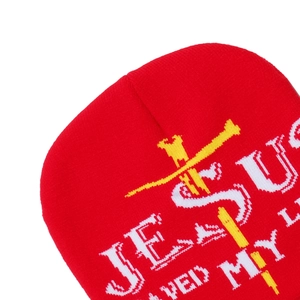 Détail du bonnet rouge avec texte Jesus blanc et broderie de croix jaune vif