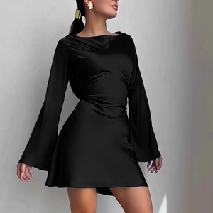 Détail d'une mini robe noire en satin avec manches évasées et texture lisse et soyeuse