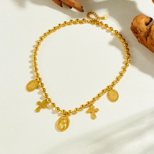 Vintage gold beaded necklace with Saint Joseph medallions and cross charms on wood decor