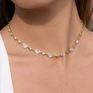 Détail du collier en forme de cœur avec maillons dorés et cristaux clairs sur mannequin