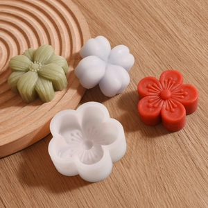 Macro detail of white silicone flower mold with various floral soap and candle crafts