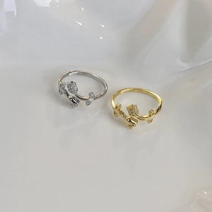Close-up of gold and silver tulip rings with micro-pave zircon on a white tray