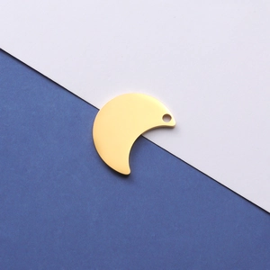 Close-up of golden crescent moon pendant with a round hole on a dual-tone background