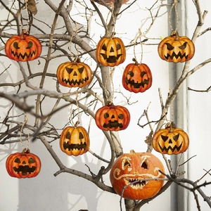 Halloween hanging pumpkin ornaments with various spooky faces on rustic wood branches