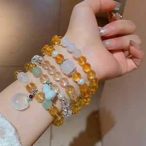 Detail of beaded bracelets with white chalcedony fox pendant and yellow crystal beads
