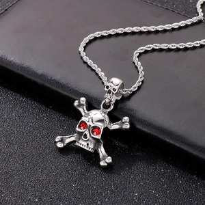 Close-up of hip hop style skull and crossbones pendant with red gem eyes on black leather